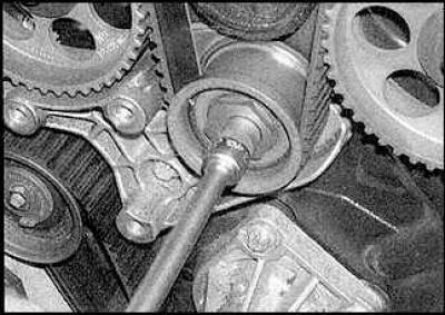 8. Turn the tensioner pulley clockwise until it stops and tighten the nut.