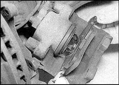7. Remove the caliper. Remove the outer brake pad from the caliper mounting bracket.