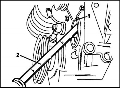 6. Remove the front oil seal (1) using a screwdriver (2) from the camshaft drive cover as shown in…