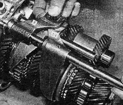 Фотография 19.30В. Вставить шток 3/4 передач в вилку 3/4 передач и собачку 5 передачи.