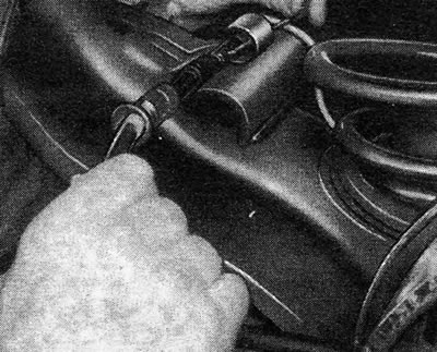 Figure 9.66 - Releasing the handbrake cable from the rear axle guide