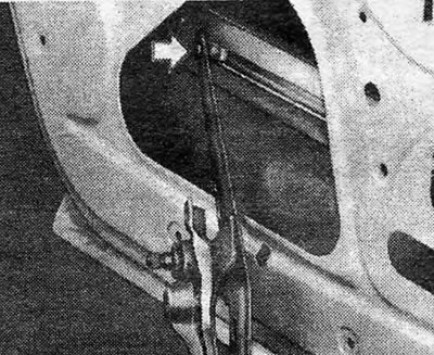 Рисунок 11.14. Отсоединение регулятора стекла задней двери (указан стрелкой) от держателя стекла