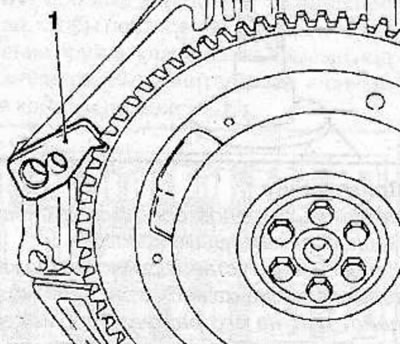Using the special tool KM-652 (1), block the flywheel from turning and unscrew the flywheel…