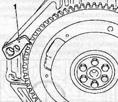Using the special tool KM-652 (1), block the flywheel from turning and unscrew the flywheel…