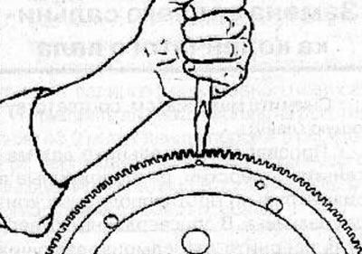 Using a hammer and chisel, break the ring gear in the area of the drilled hole and remove it from…