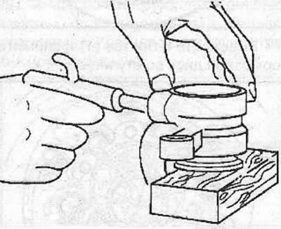 Remove the piston from the caliper. To do this, place a wooden block between the piston and the…