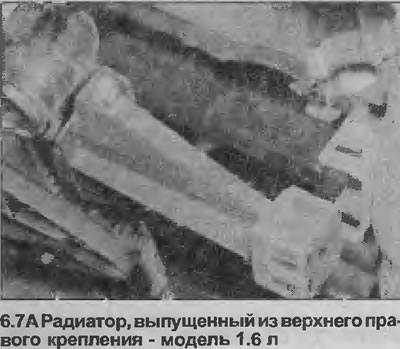 7. Înclinați partea superioară a radiatorului spre motor pentru a-l elibera de suporturile…