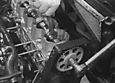 3. Tighten the crankshaft pulley mounting bolt to the specified torque while holding the camshaft…