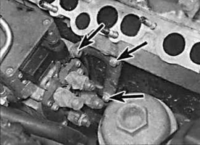4. Through the hole in the lower sprocket, unscrew the mounting bolts (1) of the front part of the…