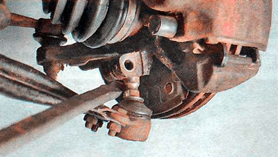 5. Манціроўкай адціскаем рычаг уніз да выхаду пальца шаравой апоры з хамута паваротнага кулака.