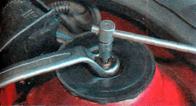 3. Утрымліваючы шток амартызатарнай стойкі ключом TORX Т30, саслабляем гайку верхняга мацавання.…