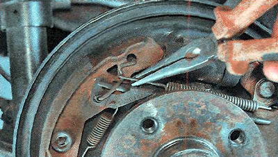 4. Using pliers, remove the upper tension spring.