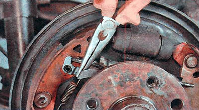 6. Remove the pawl with the spring of the automatic adjustment device.