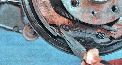 7. Using pliers, remove the lower tension spring.