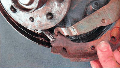 12. Press the spring of the parking brake cable, disengage the cable from the brake shoe lever and…