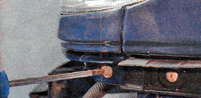3. Za pomocą klucza TORX T25 odkręć boczną śrubę mocującą dolną ozdobną listwę reflektora.