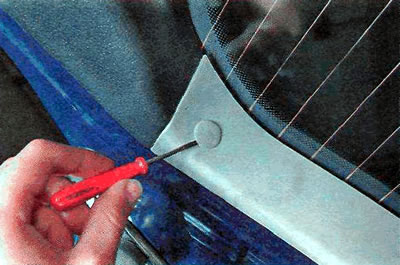 2. Using a thin slotted screwdriver, remove the two plugs from the left and right trim panels of…