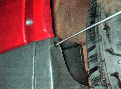 3. Using a thin screwdriver, push the rear door sill trim retainer clip inward...