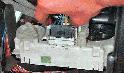 18. Naciśnij boczne zapięcia złącza wiązki przewodów wentylatora elektrycznego i odłącz złącze od…
